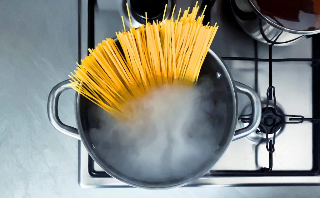 pot of pasta boiling on a stove with rising steam