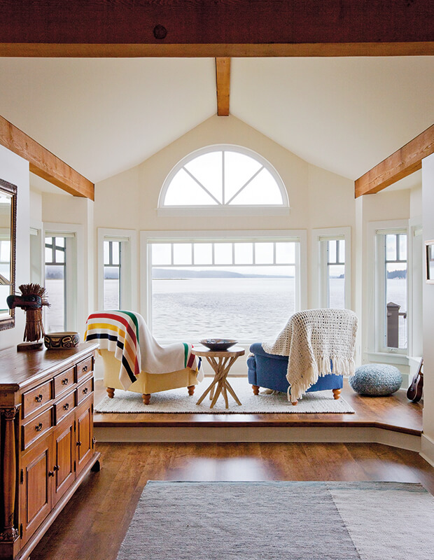 Kim Cattrall's cozy living room with huge window looking out onto water 