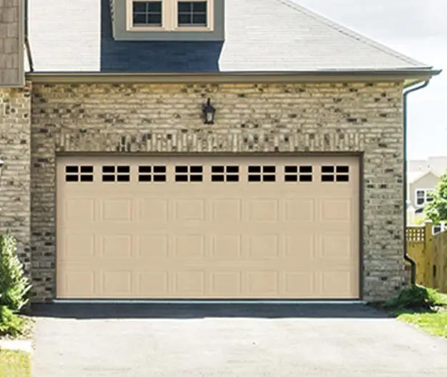 Polyester finish garage door in beige with windows across the top.