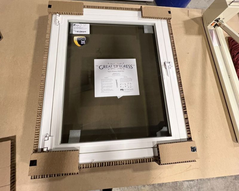 A photo of a new egress window from The Great Egress Co., in a shipping box.