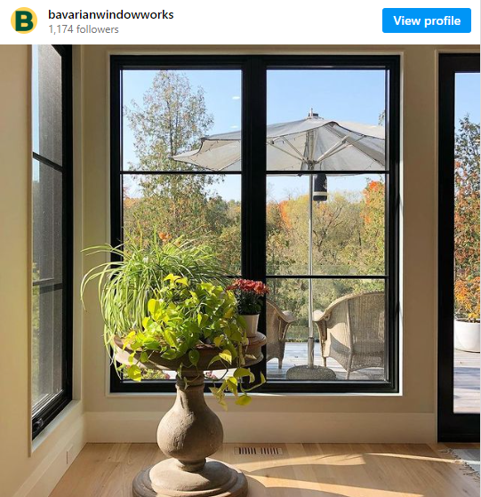 An Instagram post by Bavarian Window Works featuring a home with black windows.