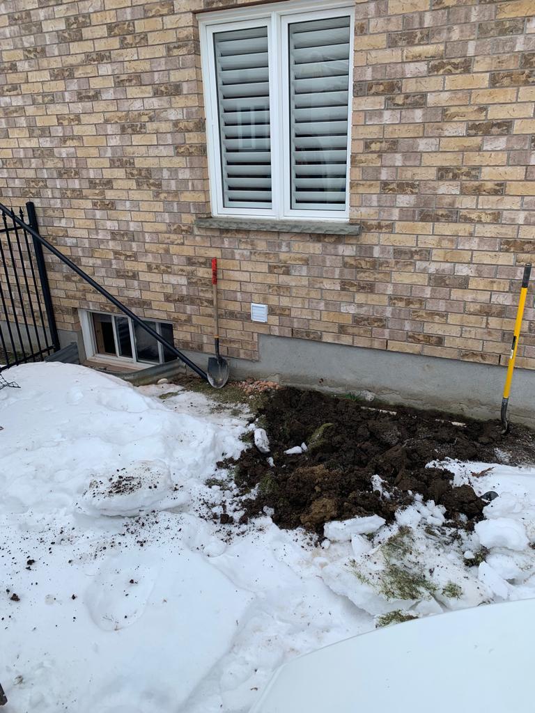 Excavating an area for an egress window installation.