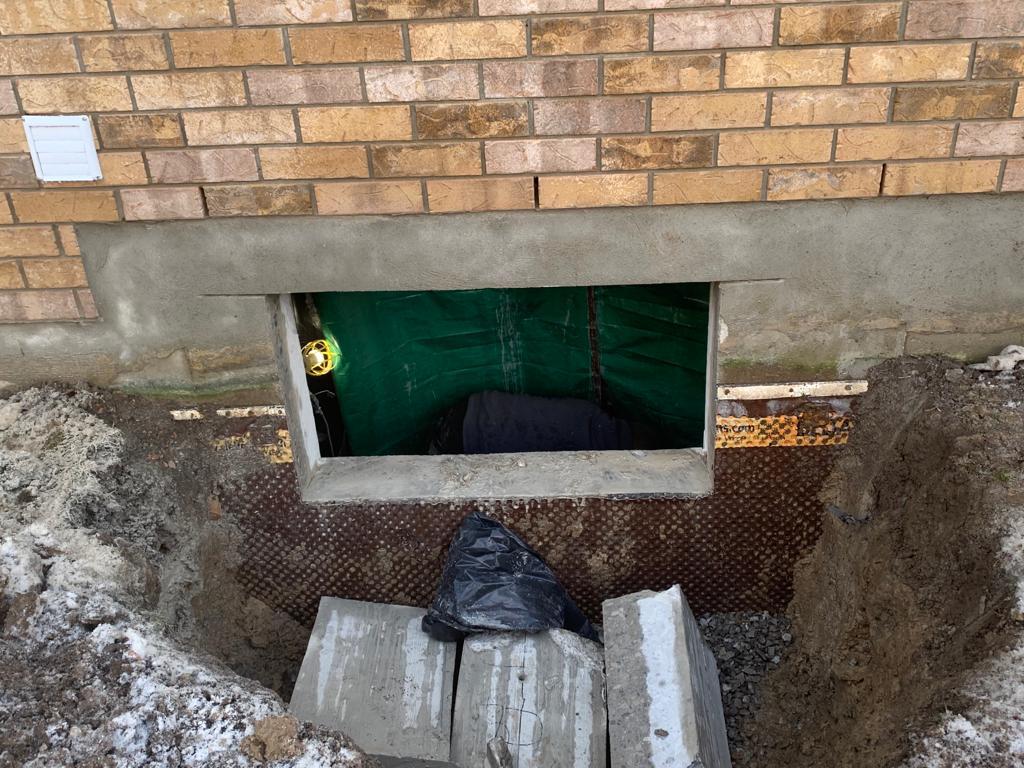 A cut-out to install an egress window into a basement wall.